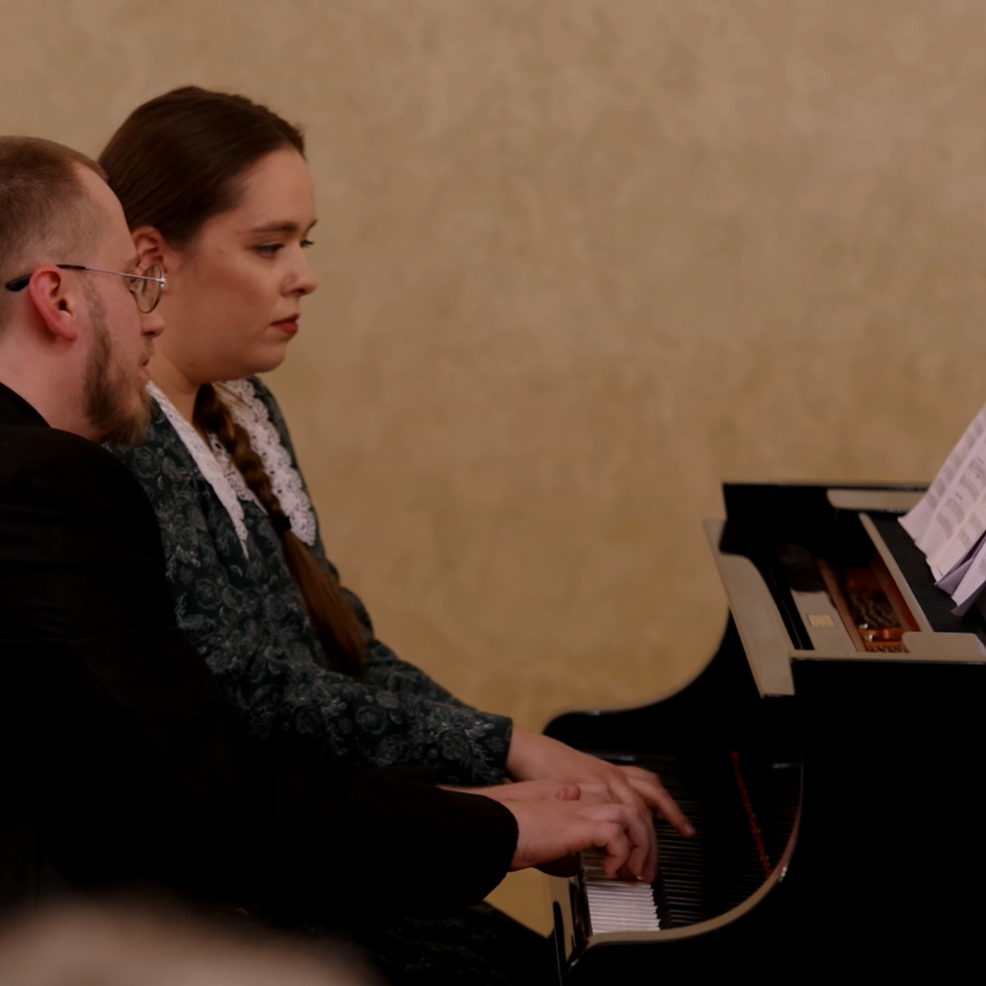Иван и Мария за роялем исполняют композицию